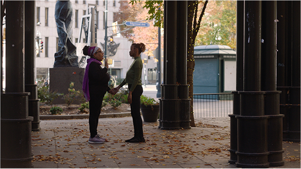 Dazon holding the hand of a woman as they walk